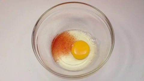 Burning spice spreads over surface egg in bowl. Slow motion Stock Footage 76148972