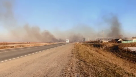Burning steppe along the road. Stock Footage