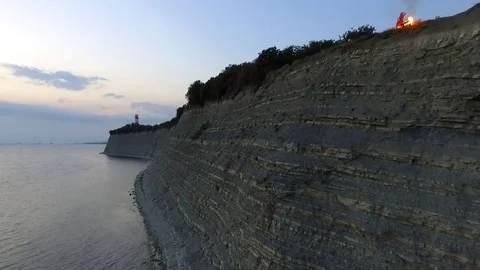 Burning suitcase falls from a cliff in Black Sea Stock Footage 78774485
