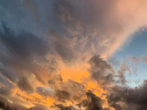 Burning sunset. A beautiful dramatic light behind evening clouds. Stock Photos