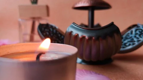 Burning tea light candle, open pomander, glass bottle with incense sticks Stock Footage 103857478