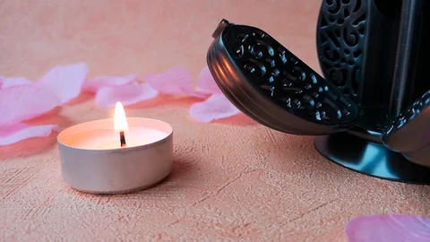 Burning tea light candle, pomander and rose petals Stock Footage 103857486