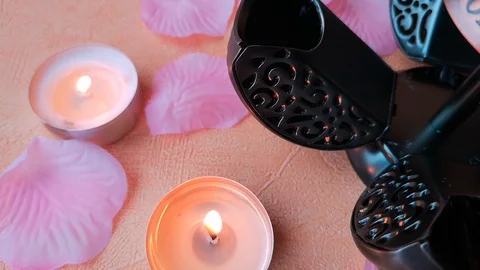 Burning tea light candles, rose petals and an open pomander. Stock Footage 103857471
