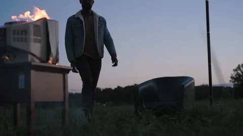 Burning television on a table in a field at dusk Stock Footage 319969729