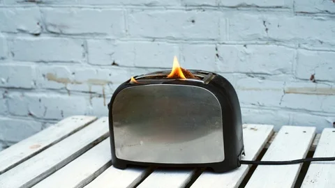 Burning toaster. Toaster with two slices of toast caught on fire over white Video stock 114697723