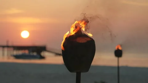 Burning torches against the background of an orange sunset Stock Footage 147357735