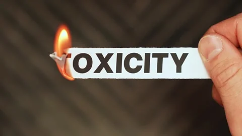 Burning “toxicity” label held by hand, symbolizing healthy boundaries Stock Footage 333655619