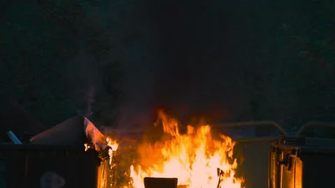 Burning trash container and old wood chair with other garbage close up. Plastic Video stock 117071252