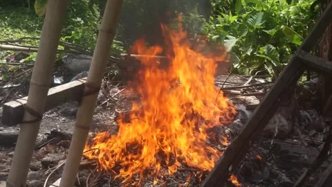 Burning trash on the ground. Flames at the junkyard. Pollution concept. 库存影片 245402502