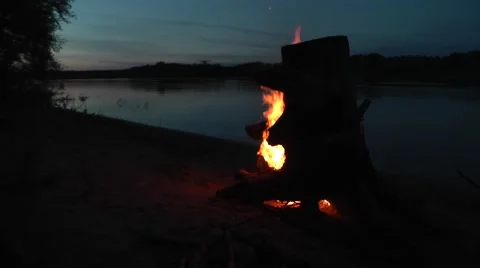 Burning tree stump on the beach by the river at night 1 Stock Footage 45882666