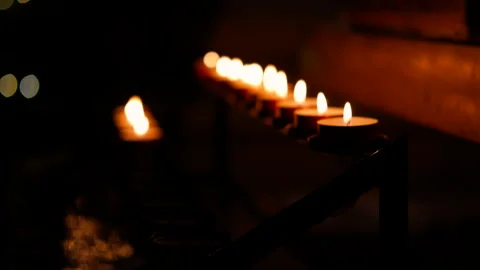 Burning votive candles in the dark creating a warm atmosphere Vídeo Stock 314223590