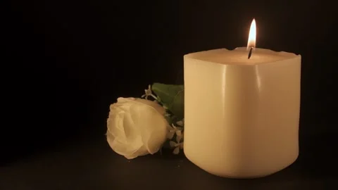 Burning white candle with flower on dark background, memorial and calm concept Stock Footage 326767250