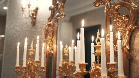 Burning white candles in classic interior with candlestick and mirror Stock Footage 99560964