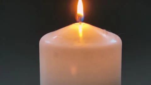 Burning white paraffin thick round candle on gray background Stock Footage 328052324