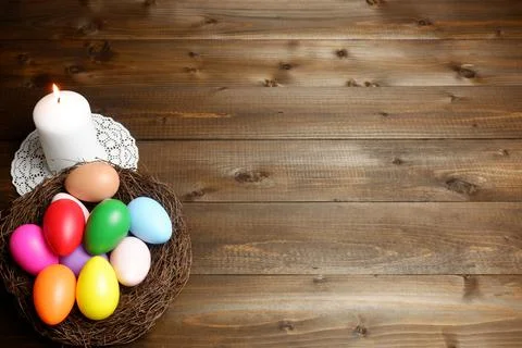 Burning white wax candle on openwork napkin, birds nest 스톡 사진