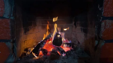 Burning wood logs creating cozy fire inside a rustic brick fireplace Stock Footage 340863247