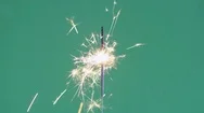 Burning Yellow Sparkler Close Up On Green Background Cinemagraph Stock Footage