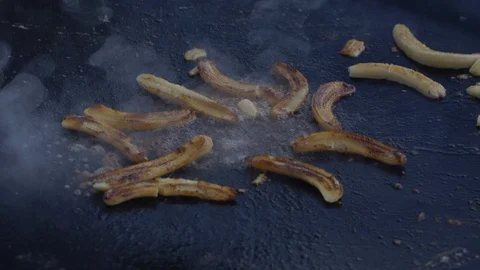 Burnt bananas smoking on griddle Stock Footage 108564897