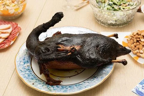 Burnt bird carcass on serving dining table. Serve charred spoiled dish. Lousy Stock Photos