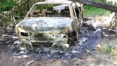 Burnt car on the side of the road Vídeo Stock 95848993