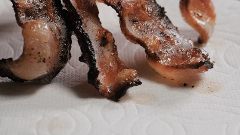 Burnt, crispy bacon slices placed over a paper towel Stock Footage 102569786