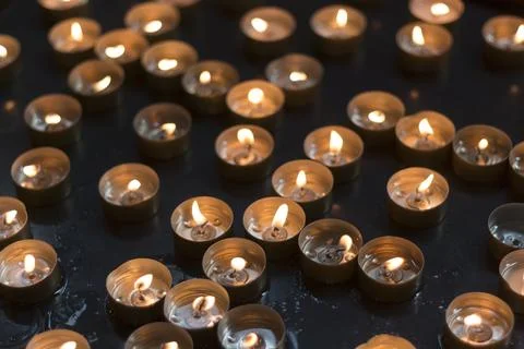 Burnt down tea lights with liquid wax in the container as well as way spilled on Stock Photos
