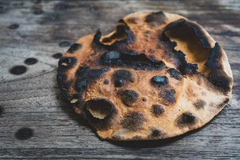 Burnt flatbread on rustic wooden table Stock Photos