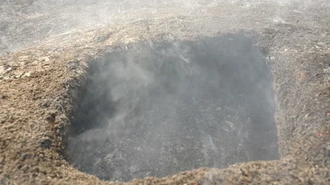 Burnt hole in the ground. Spring fire on the field. Ecological disaster in the Stock Footage 131432924