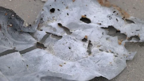 Burnt metal sheet cut by shrapnel from a shell explosion Stock Footage 196875673