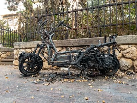 Burnt motorcycle frame after a fire on a city street. Charred metal, melted.. 库存照片