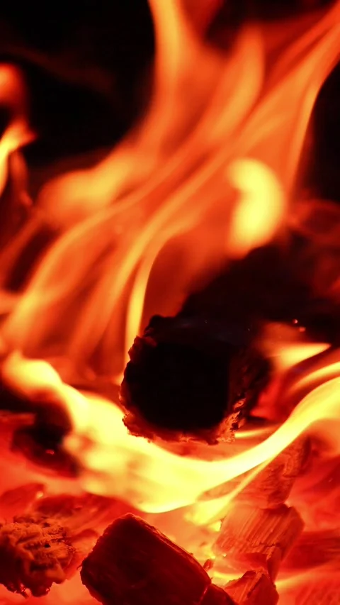 Burnt out logs break in the campfire and fall. Flames of fire are still burning Stock Footage 347711944