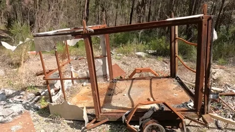 Burnt out trailer in bush Stock Footage 211003235