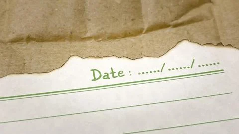 A burnt sheet of lined paper with a date on a background of crumpled cardboard Stock Photos
