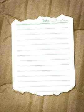 A burnt sheet of lined paper with a date field on a crumpled cardboard backgroun Stock Photos