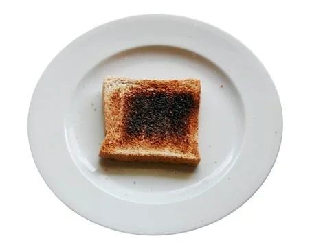 Burnt toast bread slice on dish ,isolated white backround Stock Photos