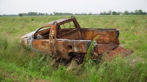 Burnt truck in the middle of a field Stock Footage 314017199