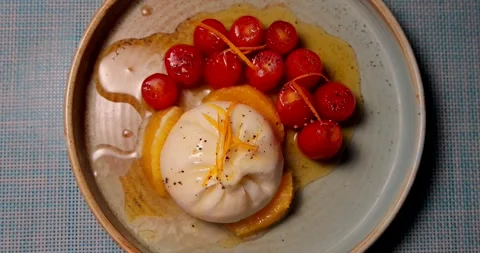 Burrata and cherry tomatoes on rustic ceramic plate. Italian cuisine, Stock Footage 311998986