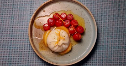 Burrata salad with cherry tomatoes and orange zest on ceramic plate Видео 311998577