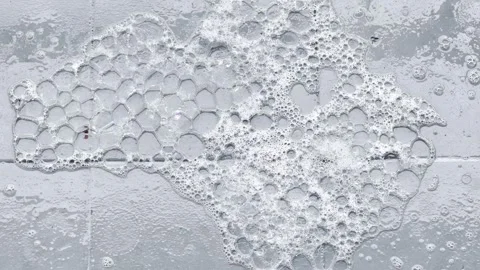 Bursting Soap Bubbles on Grey Surface — Abstract Foam Texture Stock Footage 314912735