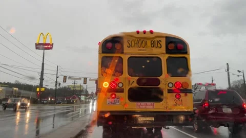 A bus and traffic at an intersection in the pouring rain in the Winter in Geo Stock Footage 147395317