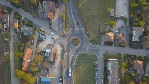 Bus and vehicles enter roundabout in timely pattern, high aerial still Stock Footage 129652822