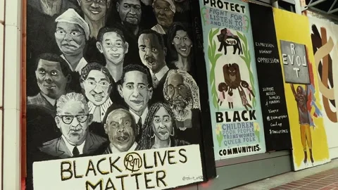 A bus crosses in front of BLM graffiti art in Portland, Oregon. Stock Footage 144188938