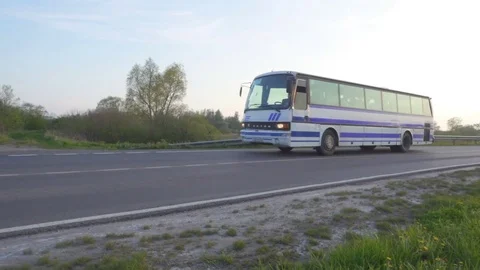 Bus drive along the road in the rays of sunset. Camera slowly rises from th.. Stock Footage 75682153