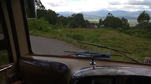 Bus driver carefully drives bus down the hill Stock Footage 112059928
