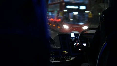 Bus Driver driving along the road at night in London United Kingdom. 库存影片 123317790