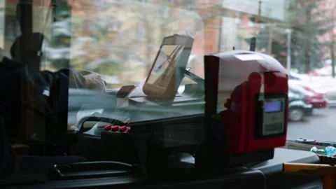 Bus driver hands on steering wheel in motion. Glass reflects movement street. Video stock 144672946