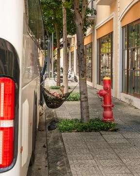 Bus Driver Resting in Hammock Under Urban Trees in Sunset Town Phu Quoc Stock Photos