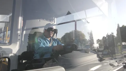 Bus Driver in Uniform Driving in City Traffic Stock Footage 253705449