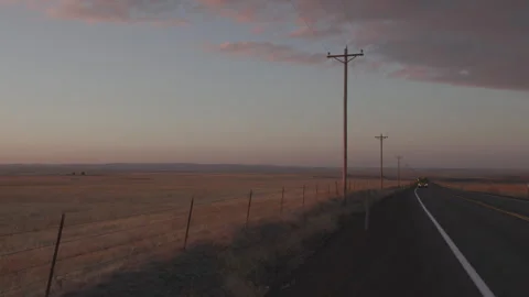 Bus drives past camera, rural highway at sunset, static shot Video stock 332084122