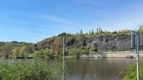 Bus, driving along a paved road at the base of a steep rock formation beside a Stock Footage 333699833